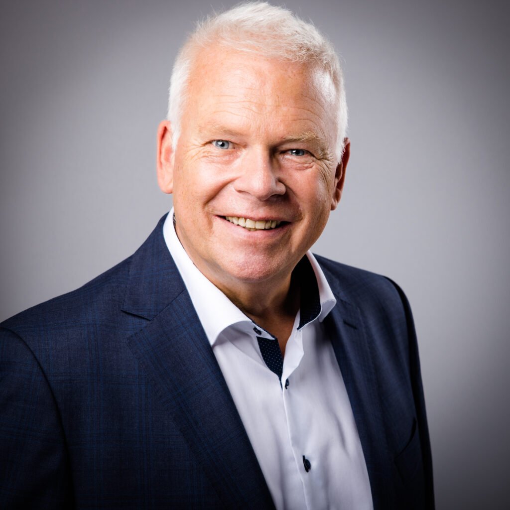 Martin Ellenberger im Sakko und weißen Hemd von vorne links